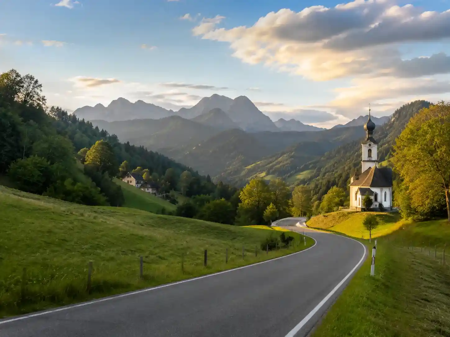 Bayerische Landstraße mit Kirche und Alpenblick